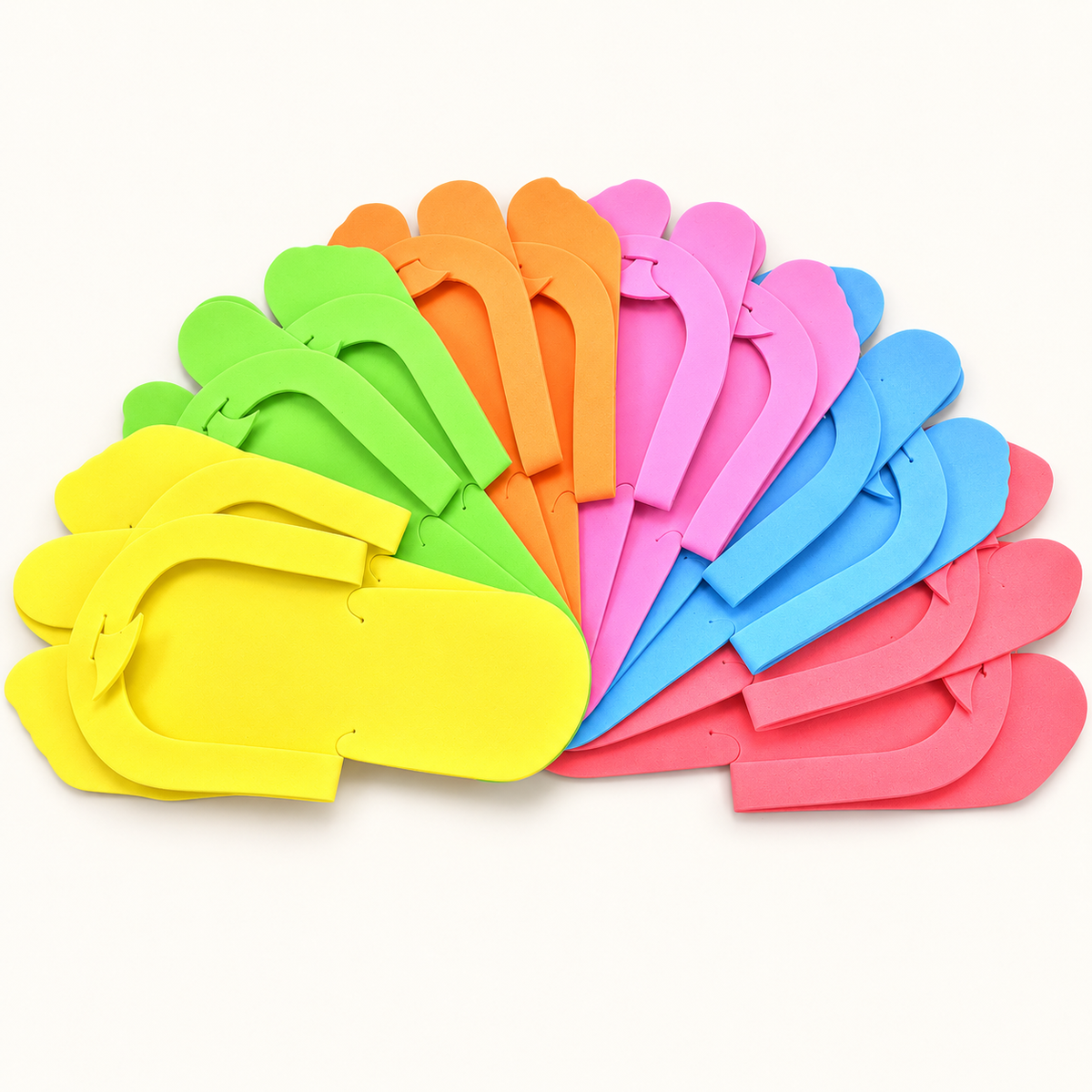 Assorted pre-folded foam pedicure slippers on an ivory background